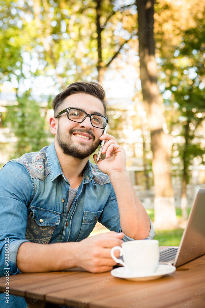 Freelancer hipster man speaking over mobile phone Freelancer hipster man speaking over mobile phone