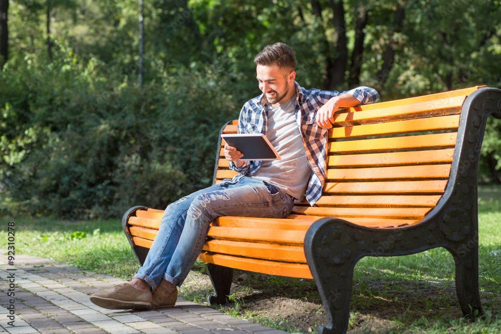 Young man working on tablet PC outdoors Young man working on tablet PC outdoors