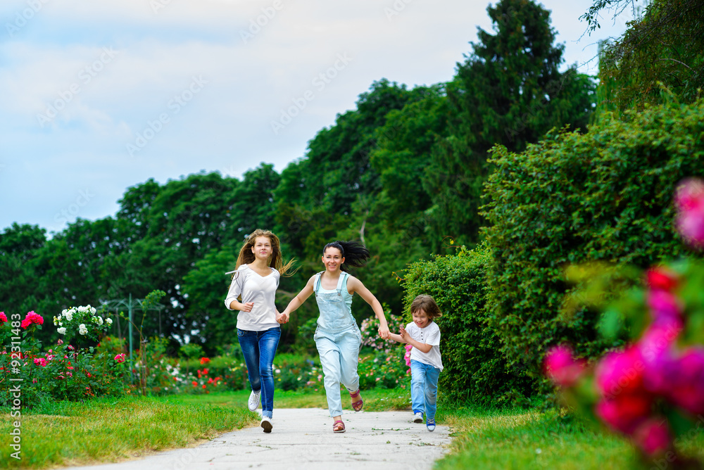 Happy Mother with daughter and son running on grass smiling Happy Mother with daughter and son running on grass smiling