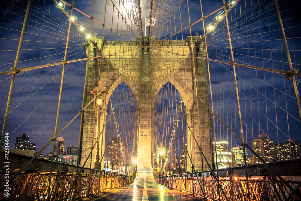 Naklejka premium Piękny Brooklyn Bridge w Nowym Jorku widziany nocą z przejścia dla pieszych