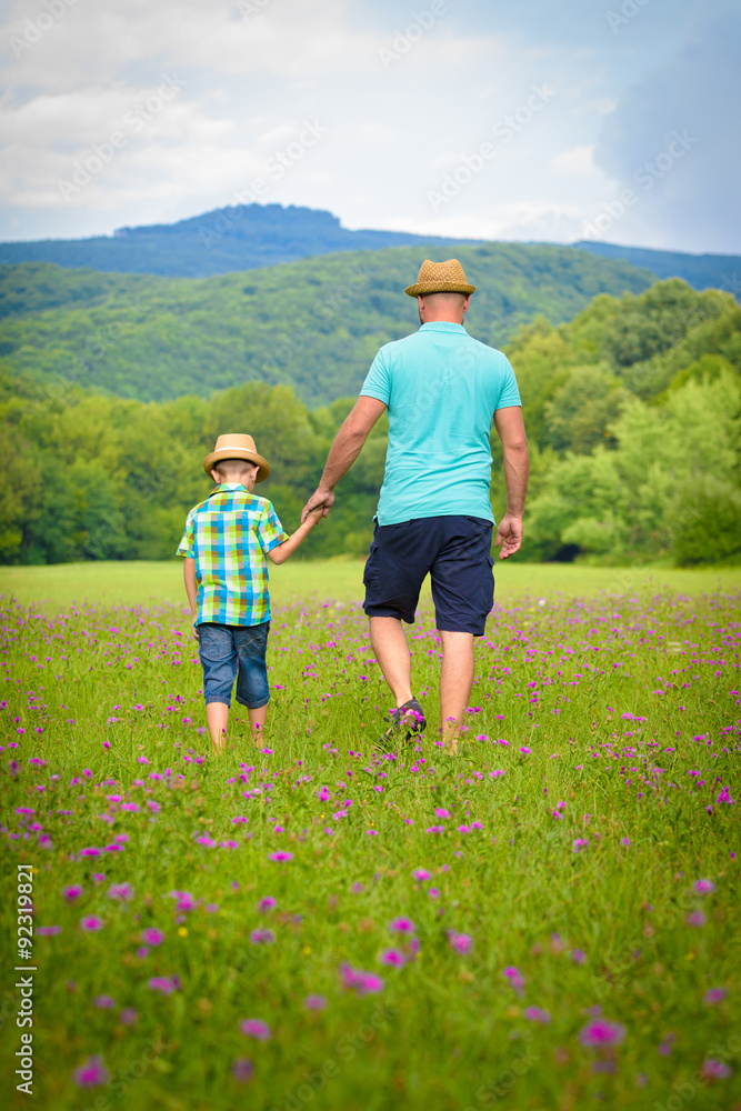 Father and son holding hands, summer family time concept Father and son holding hands, summer family time concept