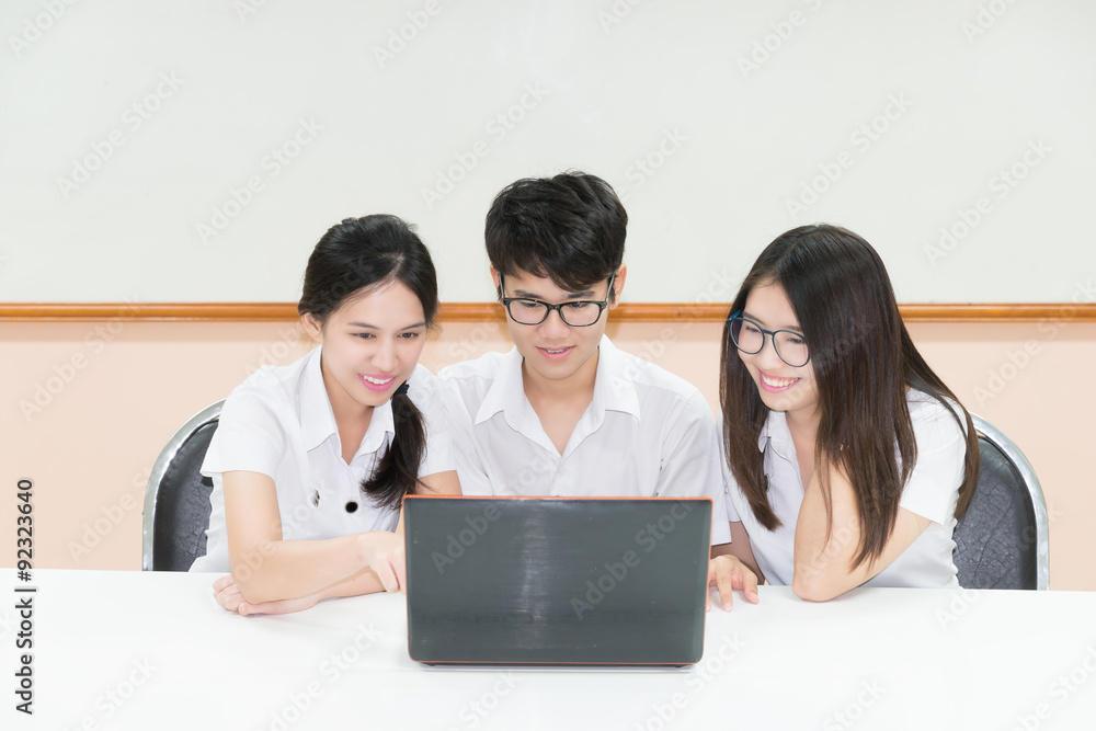 Group of Asian student in uniform E-learning through Laptop in c Group of Asian student in uniform E-learning through Laptop in c