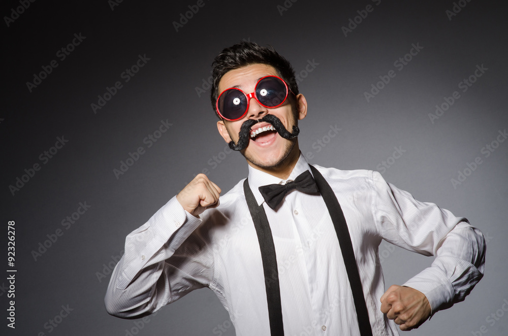 Fototapeta premium Young caucasian man wearing sunglasses against gray