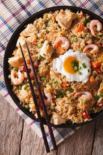  nasi goreng with chicken, shrimp and vegetables closeup vertical top view 
