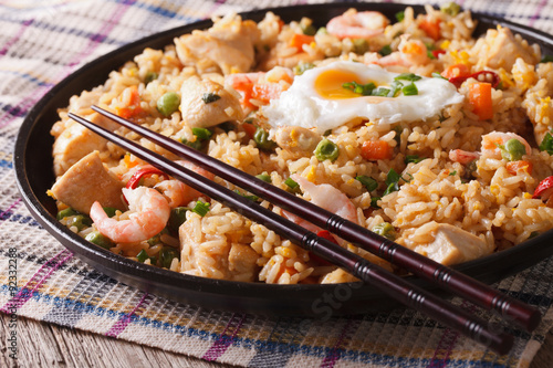 Indonesian cuisine: nasi goreng with chicken, shrimp and vegetables 
