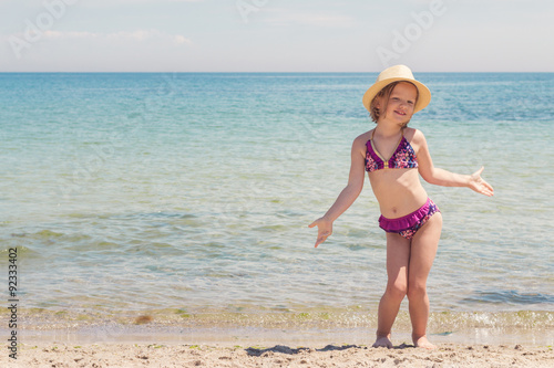 Funny little girl playing on the beach.