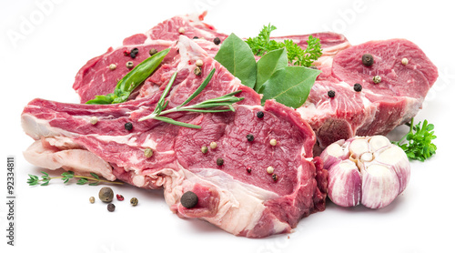 Raw pork meet steaks with spices on the white background.