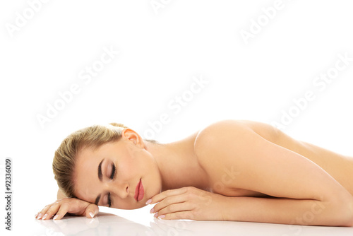 Beautiful naked woman lying on the floor.