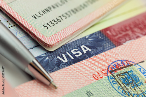 Different visas and stamps in a passport - travel background photo