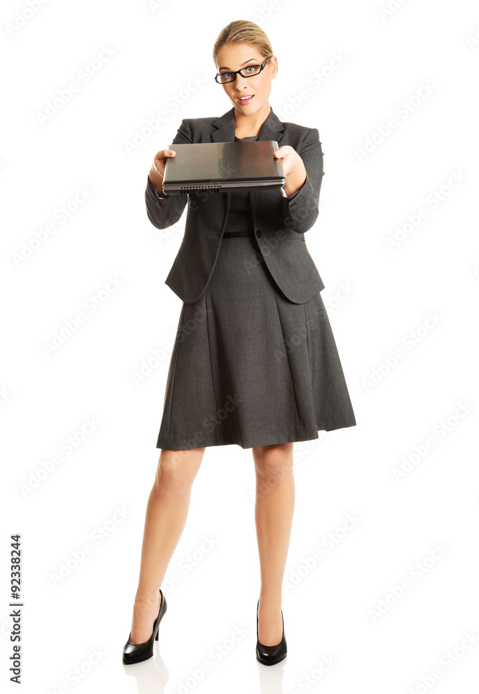 Businesswoman standing and holding a laptop Businesswoman standing and holding a laptop