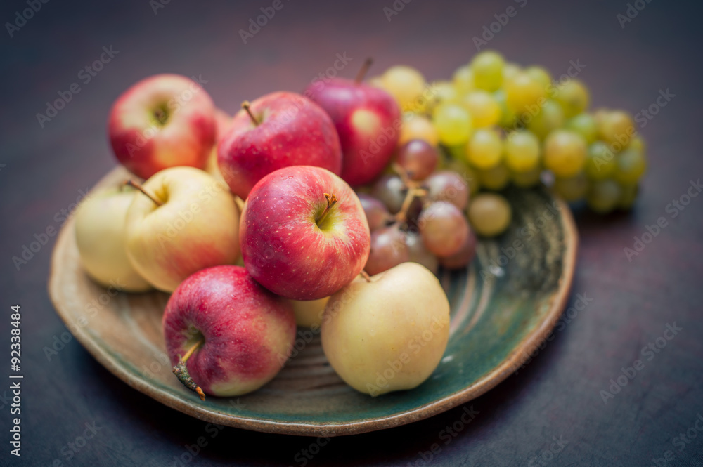 Plate with fresh autumnal fruits. apples in selective focus Plate with fresh autumnal fruits. apples in selective focus