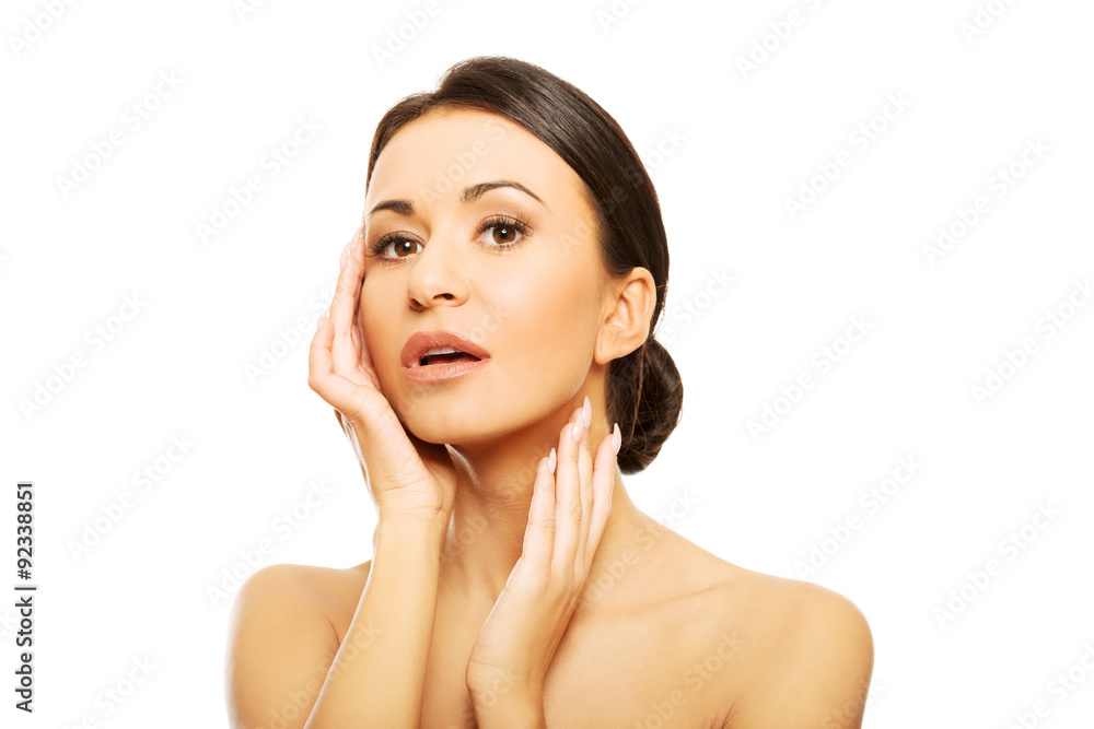 Young topless woman touching her face Young topless woman touching her face