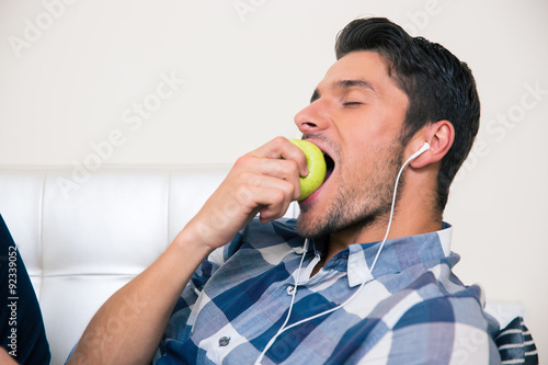 Man eating apple on the sofa