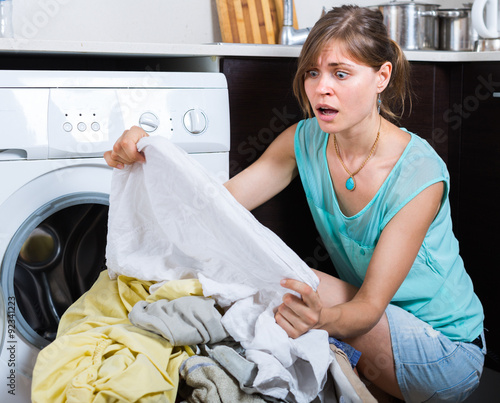 Upset maid looking at clothes photo