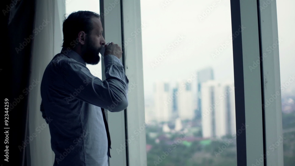 Young businessman drinking coffee and admire view from window
Young businessman drinking coffee and admire view from window