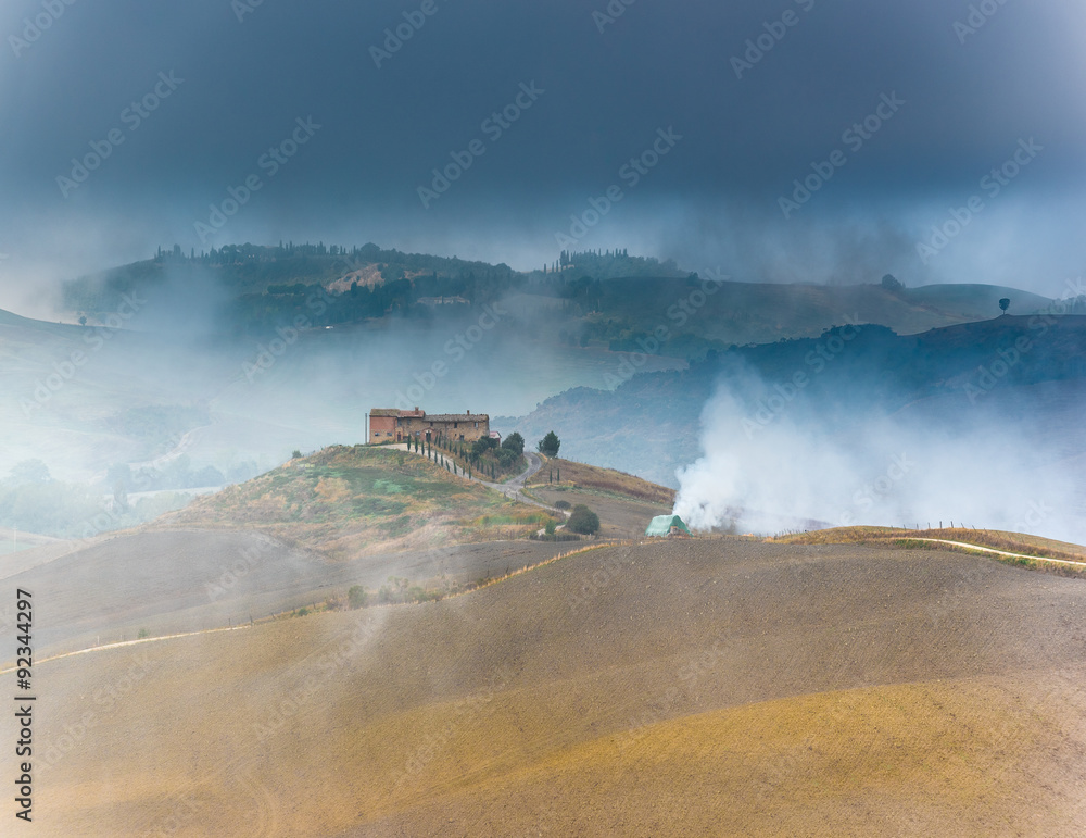 Fototapeta premium Beautiful foggy landscape in the middle sunrise. Italy, Tuscany.