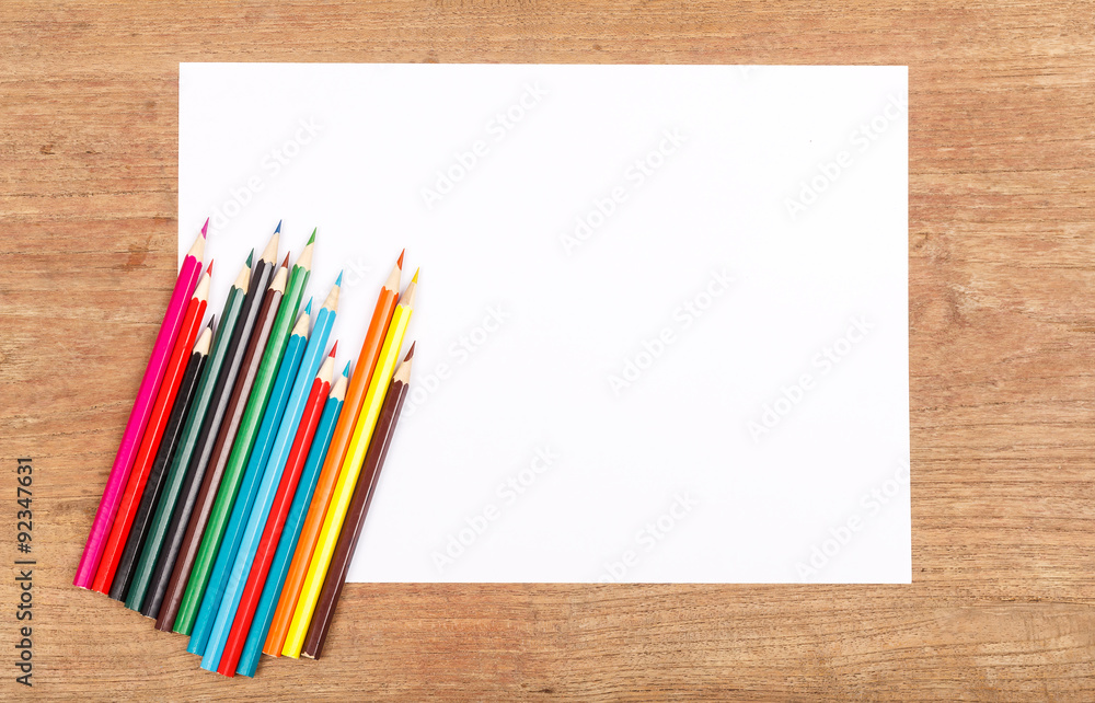Obraz premium white paper with color pencil on wooden table