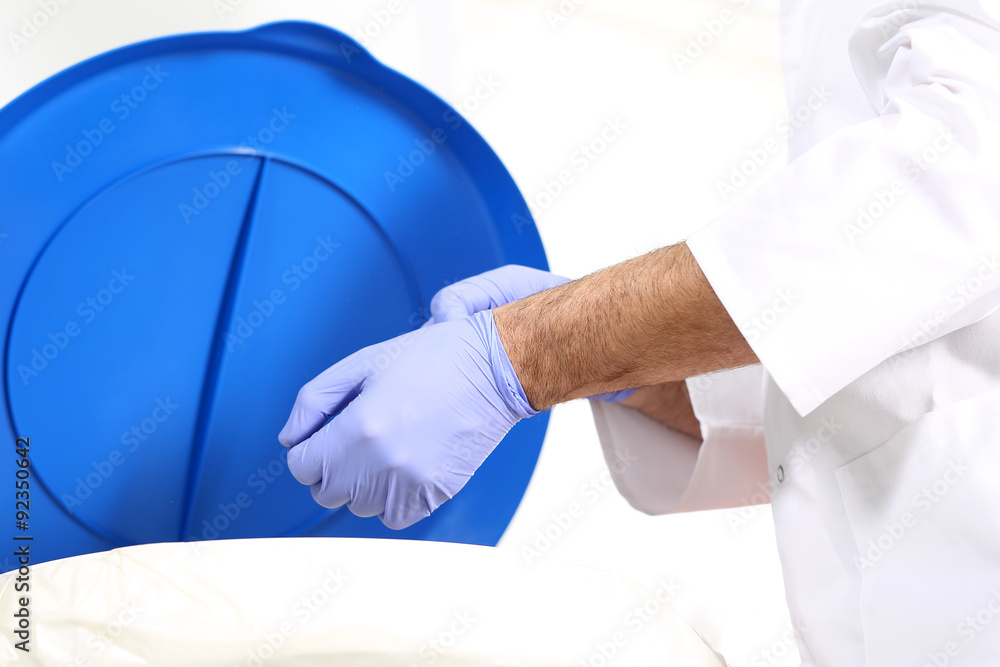 Odpady medyczne, lekarz chirurg wyrzuca rękawiczki do specjalnego pojemnika na odpady - obrazy, fototapety, plakaty 