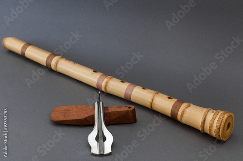 Traditional bamboo Japanese flute with Jew's harp on gray background photo