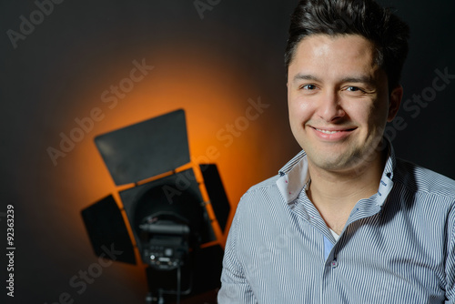 Beautiful male model posing at studio in the light flashes photo