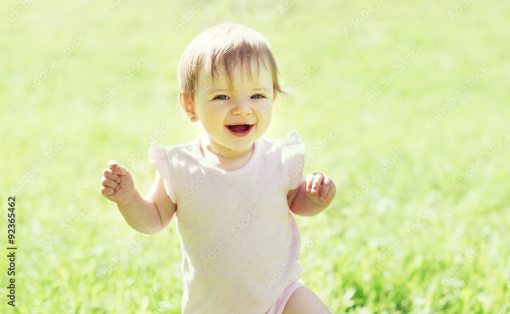 Cheerful smiling baby on the grass in sunny summer day Cheerful smiling baby on the grass in sunny summer day