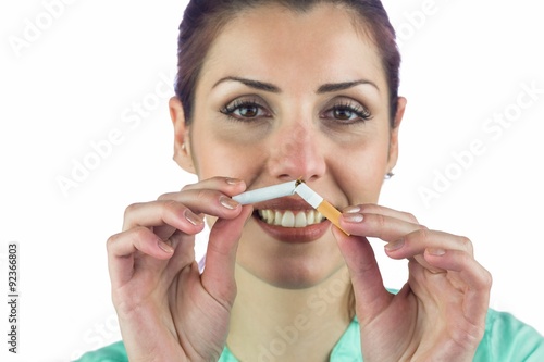 Close-up portrait of smiling woman holding cigarette 