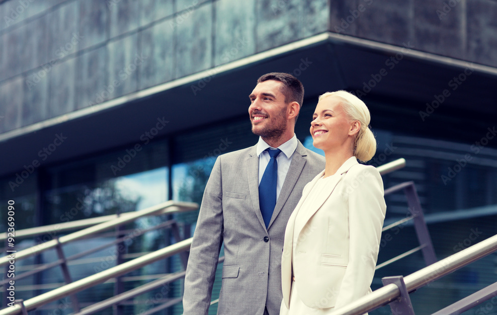 smiling businessmen standing over office building smiling businessmen standing over office building