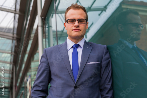 Wallpaper Mural Portrait of young businessman standing in front of office block. Torontodigital.ca