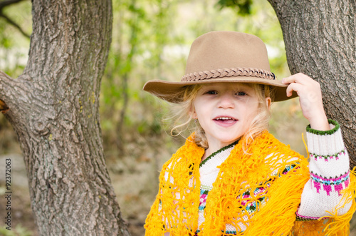 girl with hat and orange pelerine in autumn season photo