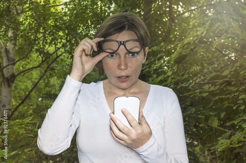 Surprised woman looking at phone