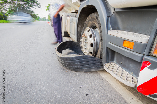 Damaged 18 wheeler semi truck burst tires by highway street, wit