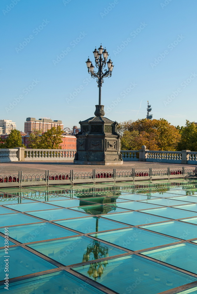 Beautiful wrought-iron lamp and its reflection in the glass on the Square in Moscow