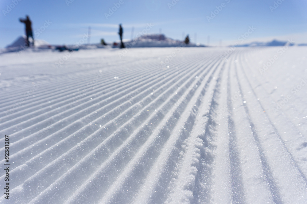 Fresh snow groomer tracks on a ski piste Fresh snow groomer tracks on a ski piste