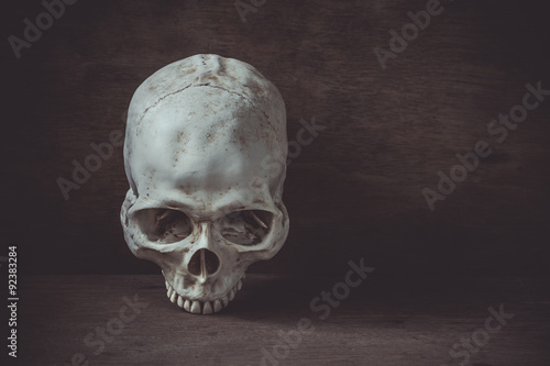 Still life photography with human skull on wood table