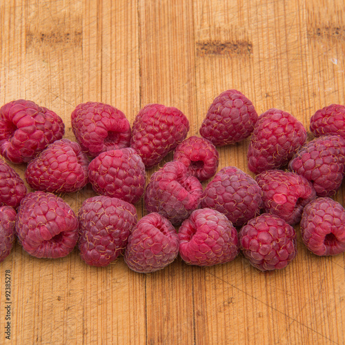Ripe sweet raspberries on wood table close-up