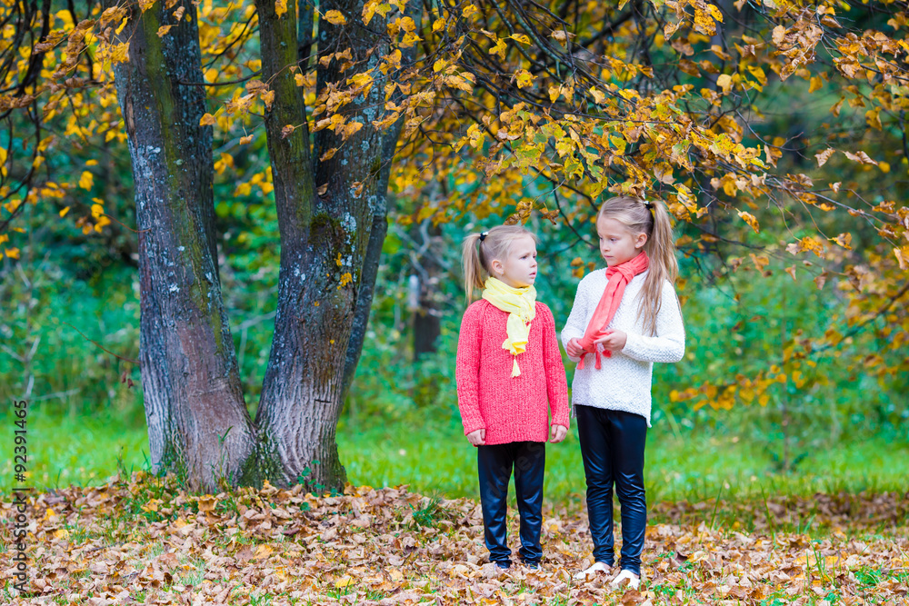 Two adorable girls in park at warm sunny autumn day Two adorable girls in park at warm sunny autumn day