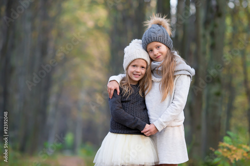 Little adorable girls outdoors at warm sunny autumn day
