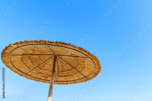 Reed umbrellas beach on the beach against blue sky