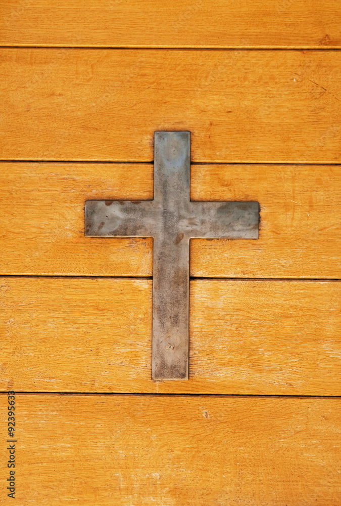 metal cross on wood background