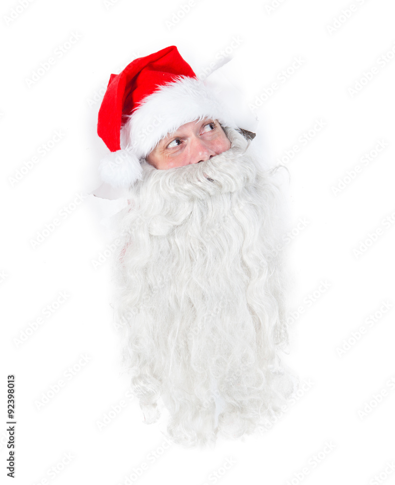 Santa Claus looking through hole in a white wall Santa Claus looking through hole in a white wall