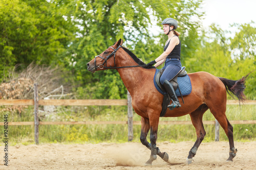 Woman jockey training riding horse. Sport activity © Voyagerix