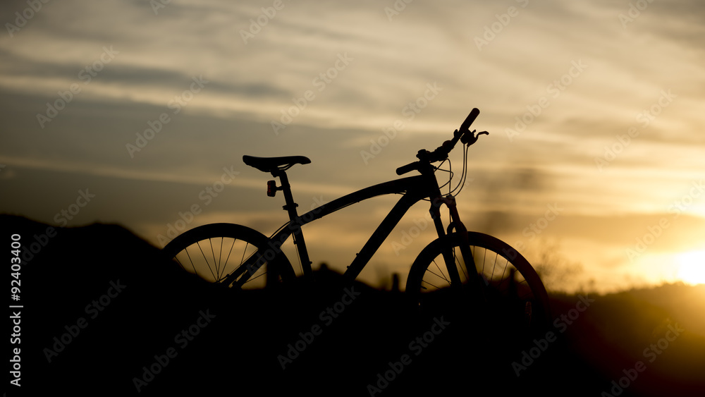 Obraz premium Silhouette of mountain bike with sunset light