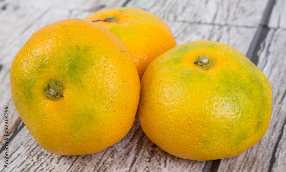 Yellow tangerine fruit over wooden background Yellow tangerine fruit over wooden background