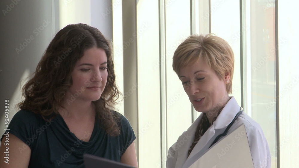 Female doctor comes in to speak to her female patient Female doctor comes in to speak to her female patient