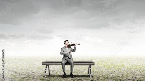 Businessman play violin © Sergey Nivens