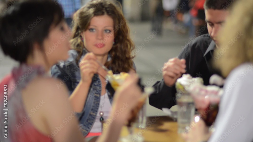 Two young couples sitting, talking, laughing and enjoying some food and drinks.
Two young couples sitting, talking, laughing and enjoying some food and drinks.