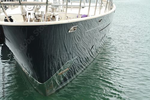 Water reflections on a shiny black hull of a luxurious yacht.