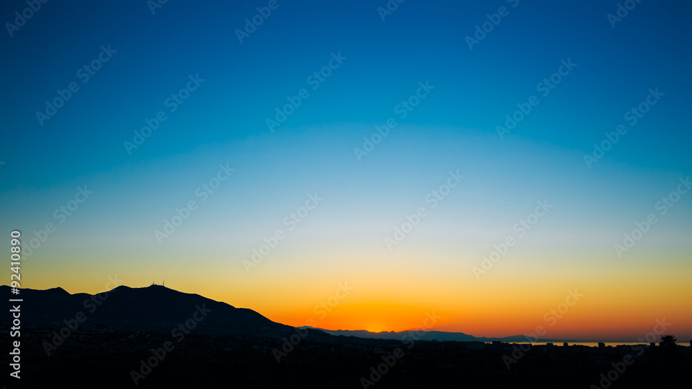 Dark Silhouette of Mountains on colorful sunrise sky background.
