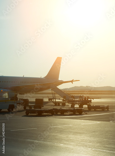 Passenger plane in the airport at sunrise. Aircraft maintenance.