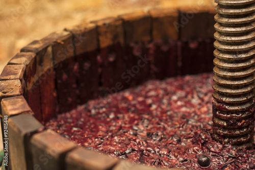 Antico torchio in legno con mosto rosso all'interno